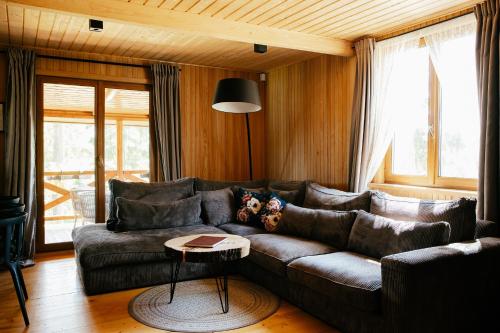a living room with a leather couch and a table at Dwa Pomosty in Augustów