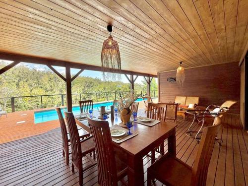 a dining room with a table and chairs and a pool at Villa Letchis, Luxe, Authenticité & Calme à l'Est in Saint-Benoît