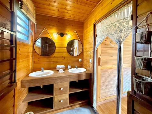 a bathroom with two sinks and two mirrors at Villa Letchis, Luxe, Authenticité & Calme à l'Est in Saint-Benoît