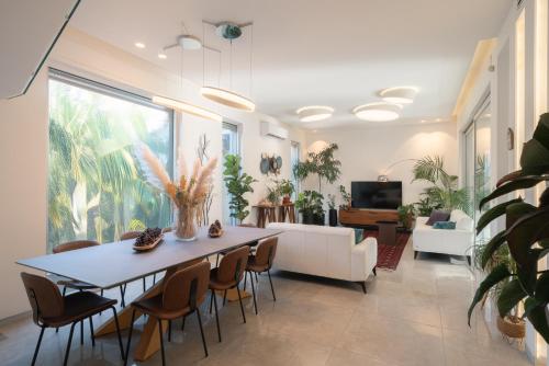 a living room with a table and chairs at Olga Resort - אולגה ריזורט in H̱adera