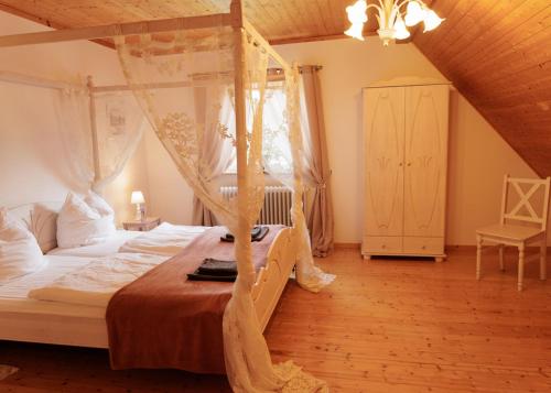 a bedroom with a canopy bed in a attic at Ferienwohnung im Landhausstil in Winkel