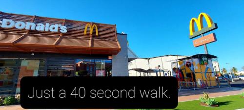 a mcdonalds restaurant with a sign that reads just a second walk at Ten Minutes From Airport - 2 in Vecindario