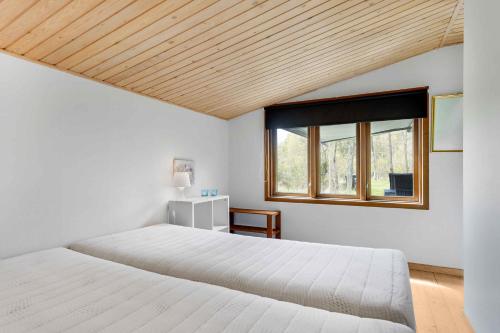 a bedroom with a white bed and a window at Charming Summer House At The Top Of Denmark in Skagen