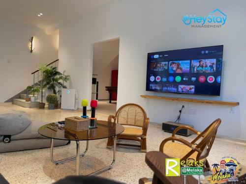 a living room with a table and chairs and a tv at MalayaVilla 5R3B16Pax PrivatePool Karaok PlayGround in Gua Sai