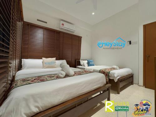 a bedroom with two beds and a sign on the wall at MalayaVilla 5R3B16Pax PrivatePool Karaok PlayGround in Gua Sai