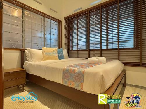 a bedroom with a large bed in a room with windows at MalayaVilla 5R3B16Pax PrivatePool Karaok PlayGround in Gua Sai