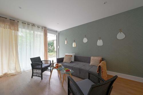 a living room with a couch and chairs and a table at Appartement familial confortable in Issy-les-Moulineaux