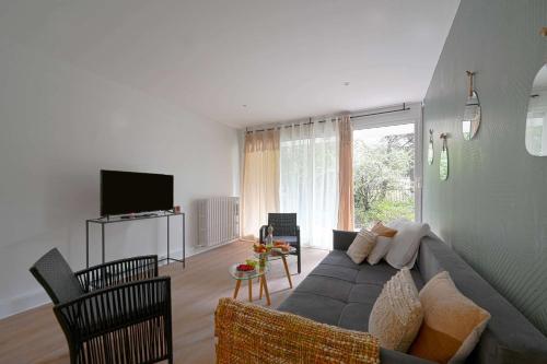 a living room with a couch and a tv at Appartement familial confortable in Issy-les-Moulineaux