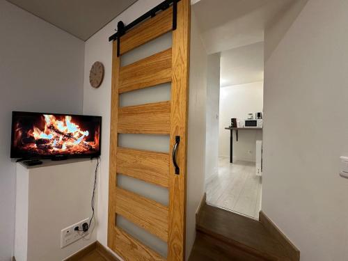 a room with a door with a tv on the wall at S Le Cocon des Francs Studio Élégant centre ville in Sedan