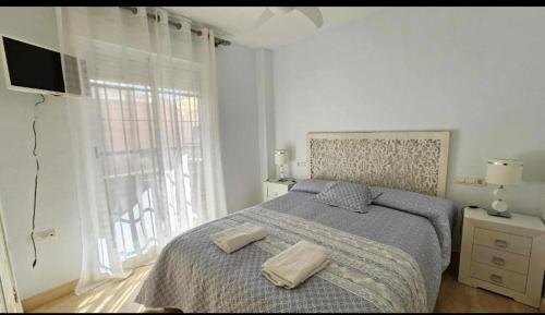 Un dormitorio con una cama con dos toallas encima. en Atardeceres en Bajoguía, en Sanlúcar de Barrameda