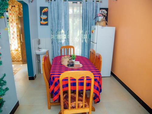 a kitchen with a table and chairs and a refrigerator at Michelle Mountain Villa Retreat in Kirua