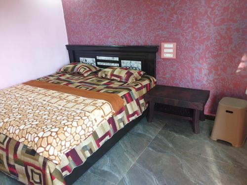 a bedroom with a bed and a table in it at RKS INTERNATIONAL HAMPi in Hampi