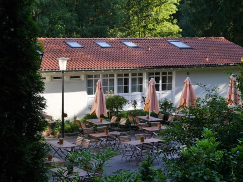 a group of tables with umbrellas in front of a building at Haus Honigstal Landhaus Café in Wuppertal