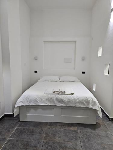 a white bedroom with a bed in a white wall at Cavour 16 Biella Studio Centro in Biella