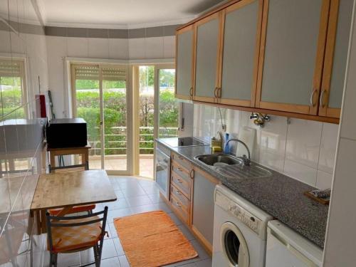 a kitchen with a sink and a washing machine at Stylish 2BR Vilamoura Escape Pool Marina Golf 15OFF in Quarteira