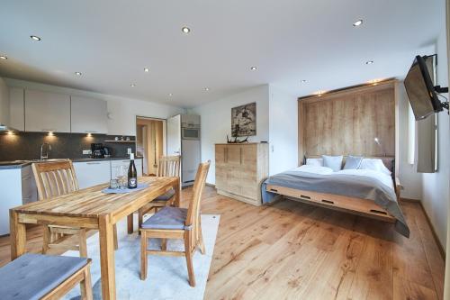 a bedroom with a bed and a table and a kitchen at Appartements Der Fuchsbau in Saalbach Hinterglemm