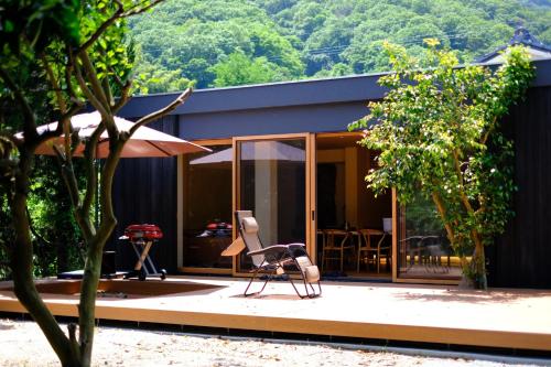 a house with a chair sitting outside of it at farm and bed SETODA in Onomichi