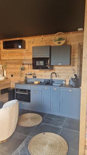 une cuisine bleue avec un évier et une cuisinière dans l'établissement Charmante escapade, à Baccarat