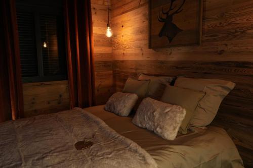 a bed in a room with a wooden wall at Charmante escapade in Baccarat