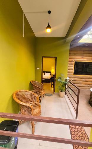 a room with yellow walls and wicker chairs at Monsoon Retreats Treehouse in Thekkady