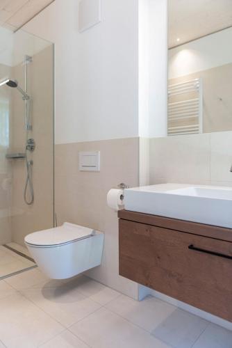 a bathroom with a sink and a toilet and a shower at Cottage am See - Your Austrian Home in Mondsee