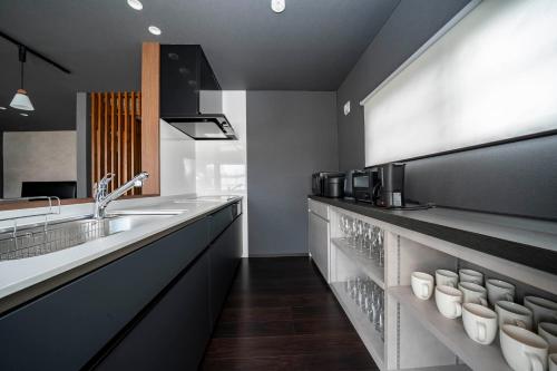 a kitchen with a sink and a counter with cups at Violet Garden in Furano