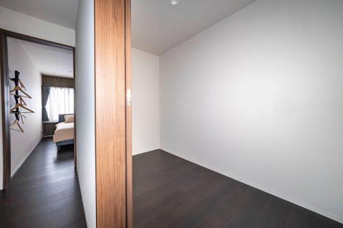 an empty room with white walls and a wooden door at Violet Garden in Furano