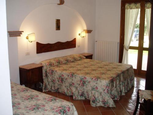 a hotel room with two beds and a window at Il Vivaio in Castiglione della Pescaia