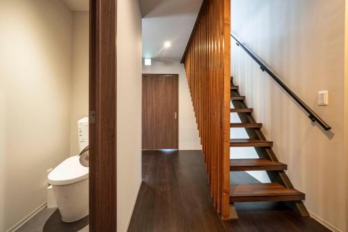 a bathroom with a staircase leading to a toilet at Violet Garden in Furano