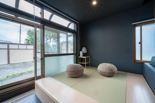 a room with two stools in front of a window at Violet Garden in Furano