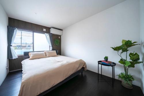 a bedroom with a bed and a potted plant at Violet Garden in Furano