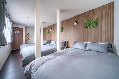 a bedroom with two beds and a wall with mirrors at Violet Garden in Furano