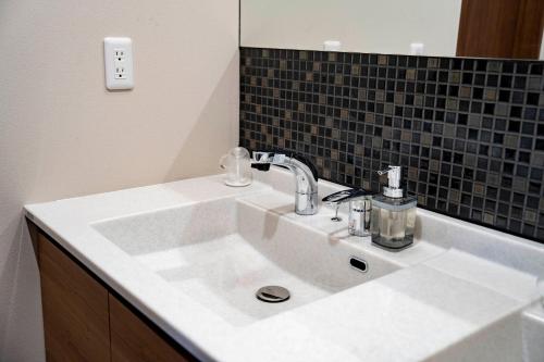 a white sink in a bathroom with a mirror at Violet Garden in Furano