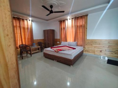 ダラムシャーラーにあるThe Tushar Homestayのベッドと天井扇風機のある寝室