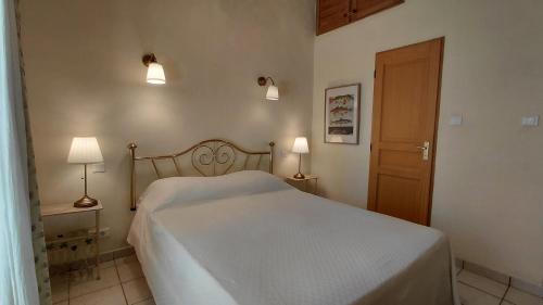 a bedroom with a bed and two lamps and a door at Gite Mimosa - Private Pool, Sainte-Valière, South of France in Sainte-Vallière