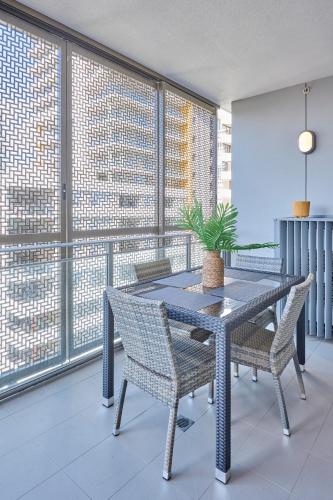 a dining room with a table and chairs and windows at Macquarie Cozy Nest 2BR with Pool Near Train Shopping in Sydney