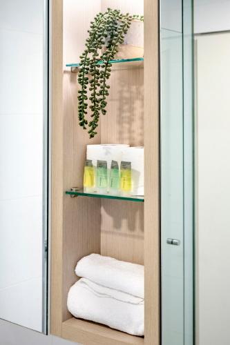 a bathroom closet with towels and a plant at Macquarie Cozy Nest 2BR with Pool Near Train Shopping in Sydney