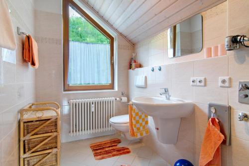 une salle de bain avec un lavabo et des toilettes et une fenêtre dans l'établissement Ferienwohnung Bodenseeblick, 