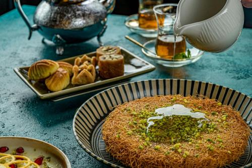 a table topped with plates of food and a pie at Sheraton Sharjah Beach Resort and Spa in Sharjah