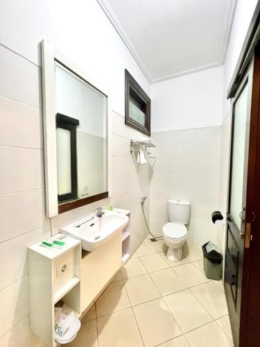 a white bathroom with a sink and a toilet at Avila Ketapan Rame Hotel in Trawas