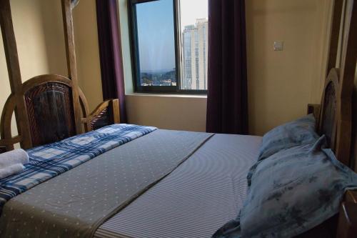 a bed in a room with a large window at Tai Africa Guest Rooms in Arusha