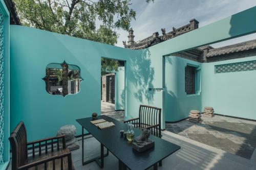 a room with blue walls and a table and chairs at PingYao Chengfu Jinyuan Hotel in Pingyao