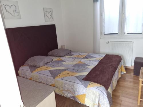 a bedroom with a bed with a colorful quilt at Maison entière paisible in Tarbes
