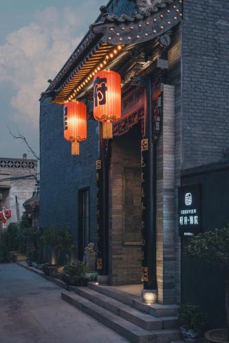 a building with orange lanterns on the front of it at PingYao Chengfu Jinyuan Hotel in Pingyao