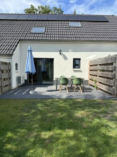 a patio with a table and an umbrella at 't Veurhuus in Ansen
