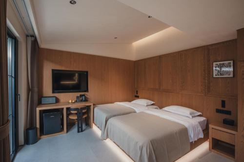 a hotel room with two beds and a television at PingYao Chengfu Jinyuan Hotel in Pingyao