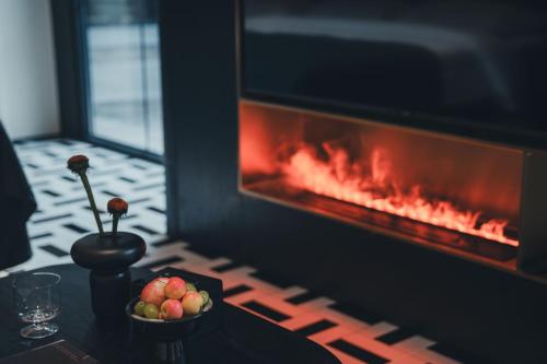 a table with a bowl of fruit in front of a fireplace at PingYao Chengfu Jinyuan Hotel in Pingyao