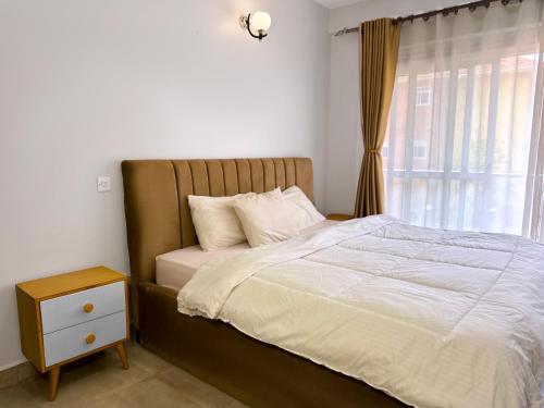 una camera da letto con un letto grande con una finestra di Spacious 3Bedroom Apartment in Muyenga, Bukasa Road a Kampala
