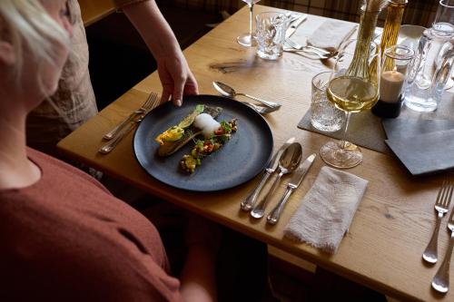 a person sitting at a table with a plate of food at Hotel loj - our kind of place in Flachau