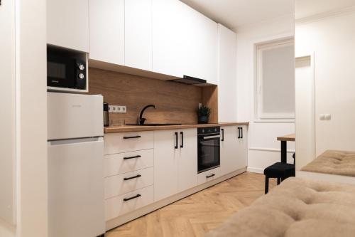 a kitchen with white cabinets and a microwave at Nest Inn Velvet Apartment in Baia Mare